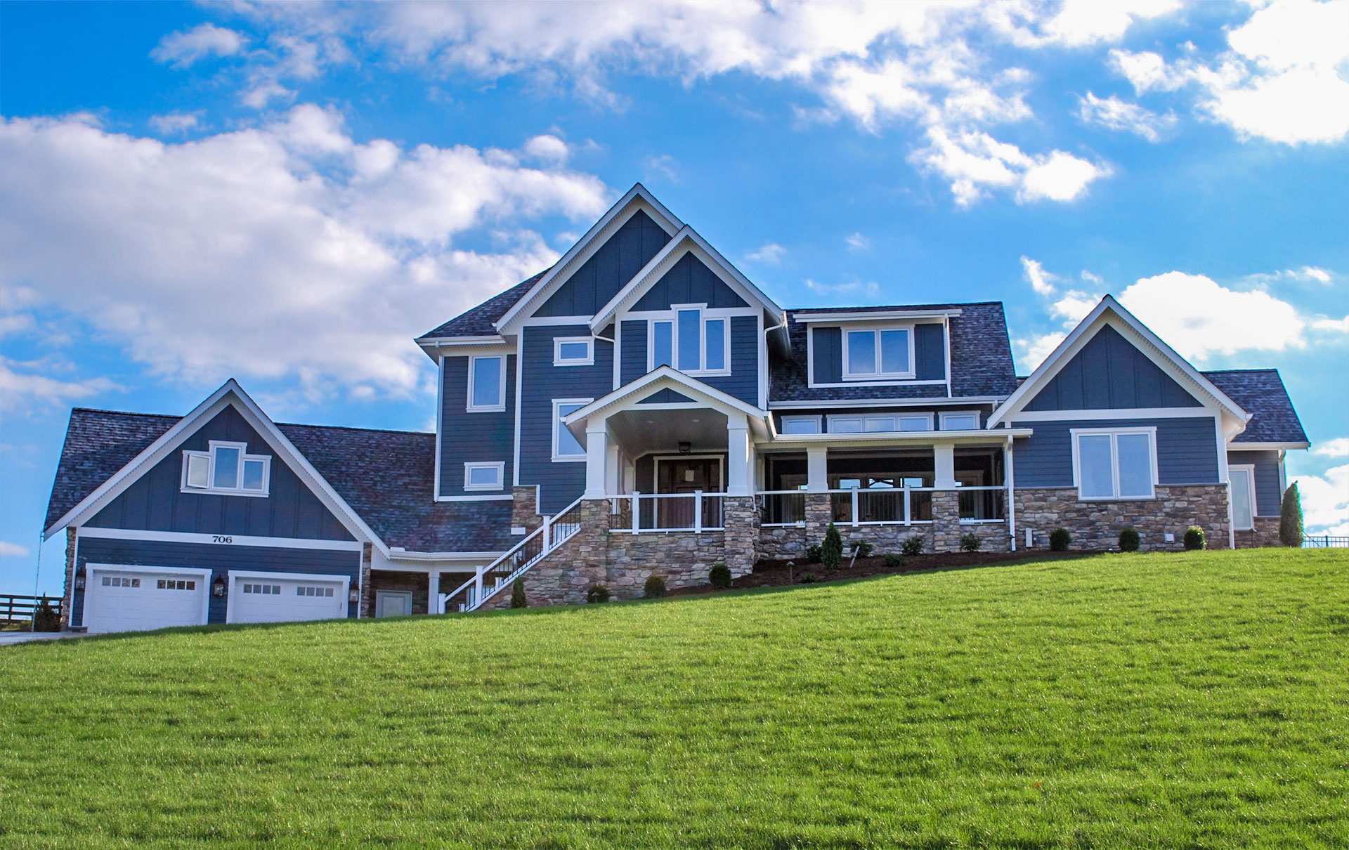 Exterior photo of a blue house on a hill.