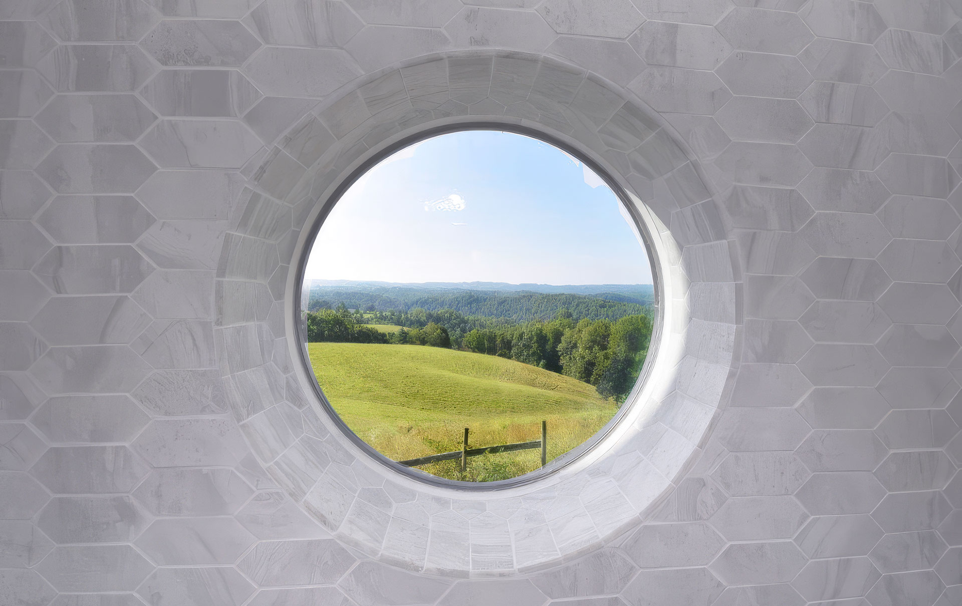 Photo of a porthole window with a field and mountain.